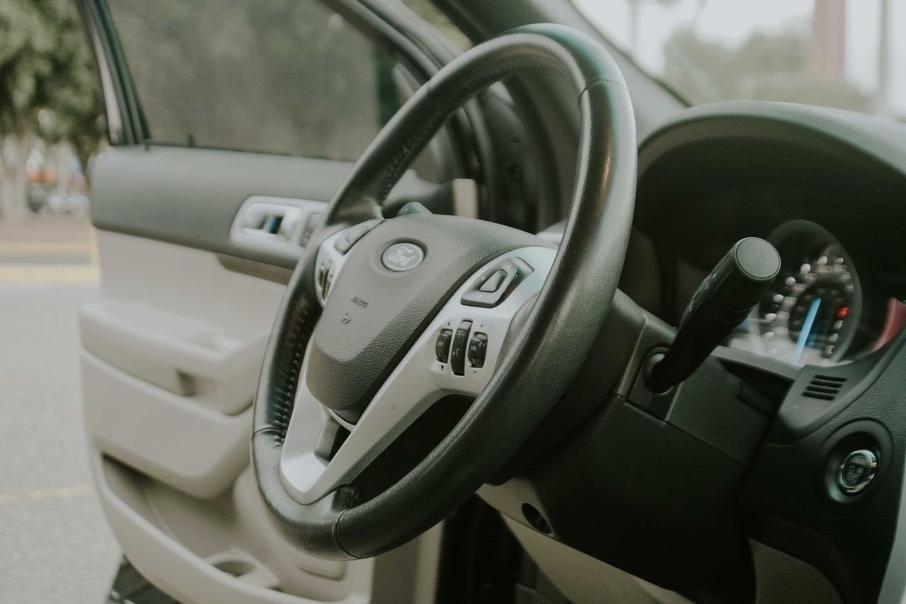 about-us Detailed view of a Ford vehicle interior focusing on the steering wheel and dashboard.