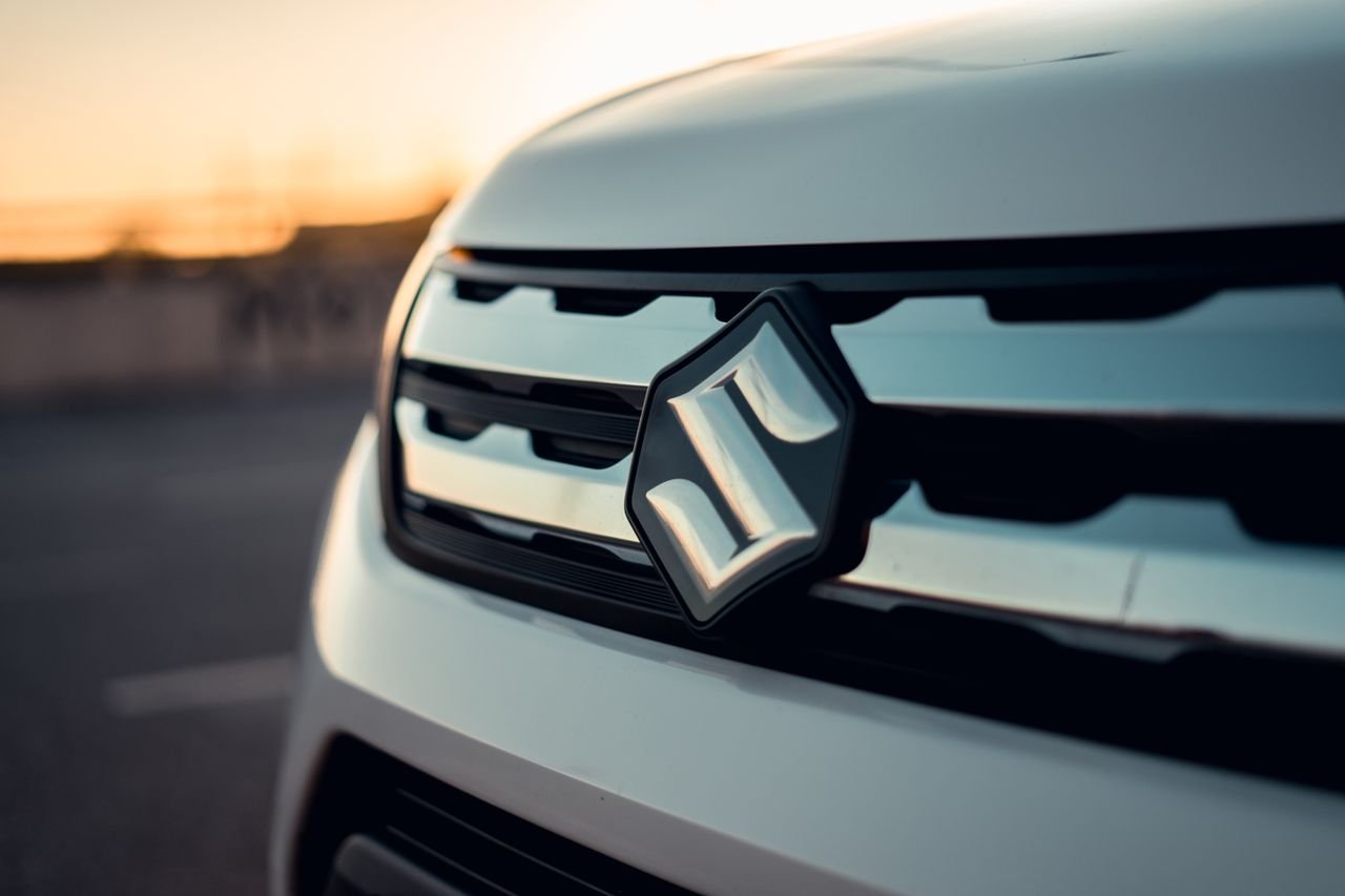 services-03 Detailed view of Suzuki car grille and logo captured at sunset, showcasing modern automotive design.
